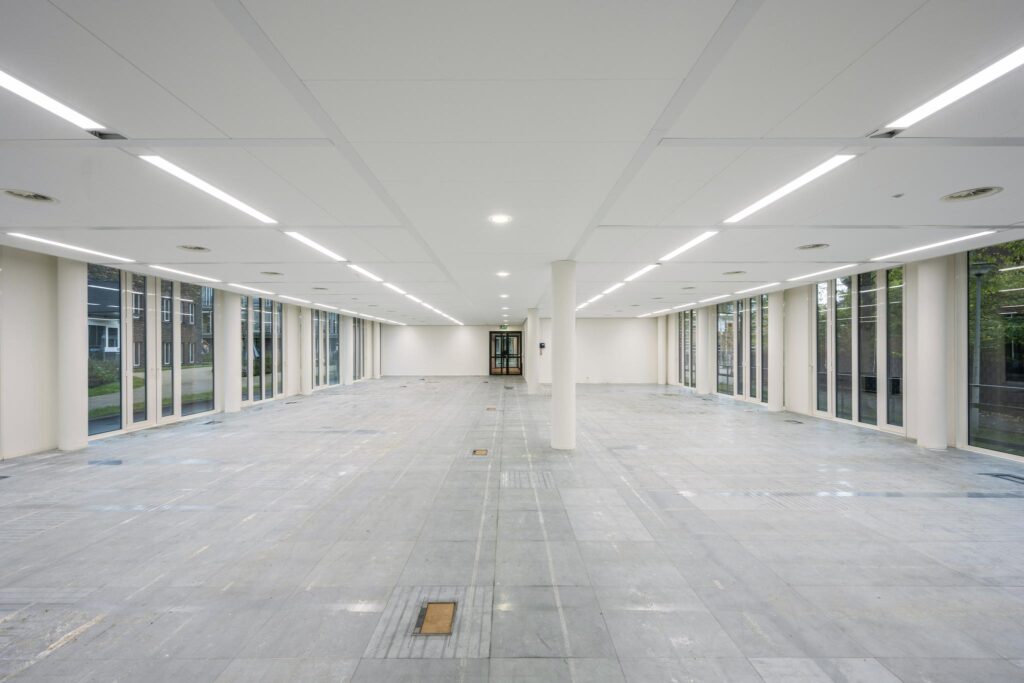 Leeg en licht kantoorruimte-interieur aan de De Cuserstraat met grote ramen en systeemplafond.